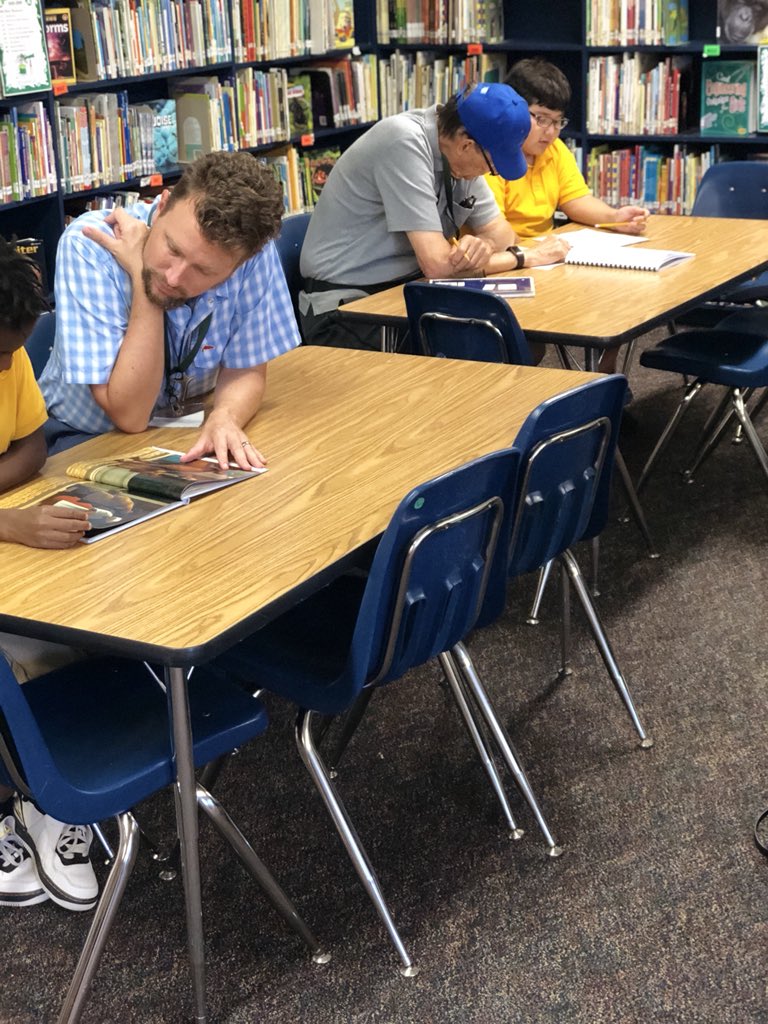 Reading Buddy volunteer reading with a student