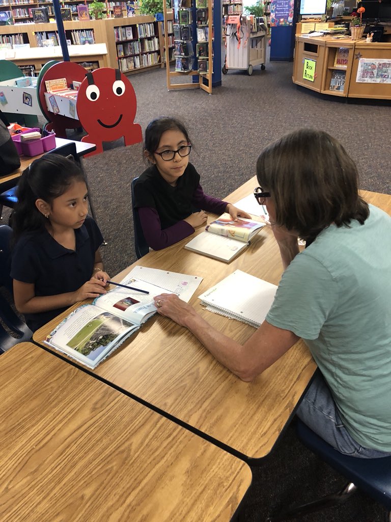 Reading Buddy volunteer reading with a student