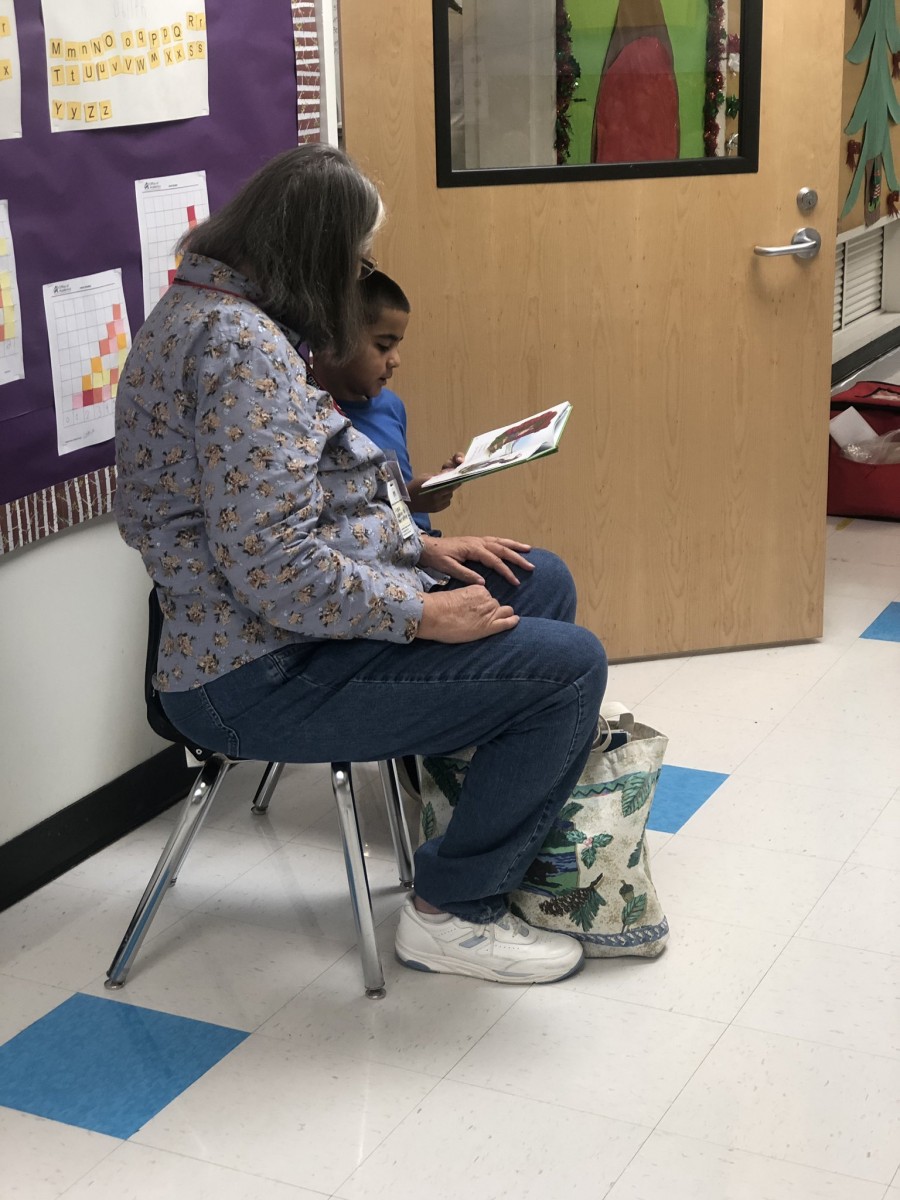 Reading Buddy volunteer reading with a student